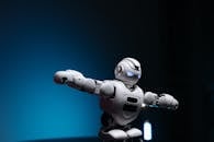 Close Up Shot of White Toy Robot on Blue Background