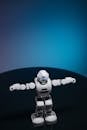 Close Up Shot of White Toy Robot on Blue Background