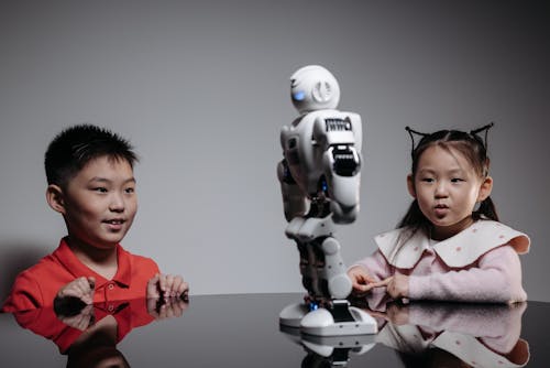 Kids Looking at White Toy Robot on the Table