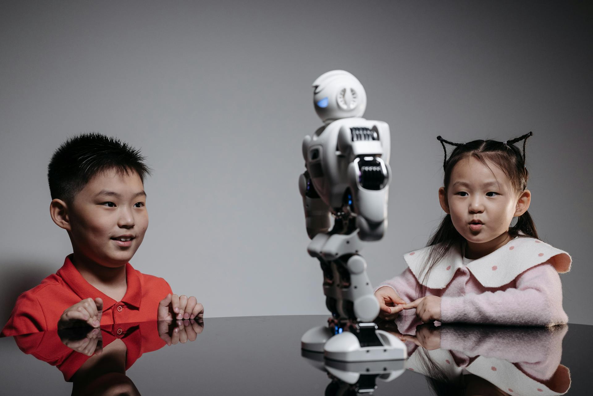 Kids amazed by a humanoid robot during an indoor play session, showcasing technology and learning.