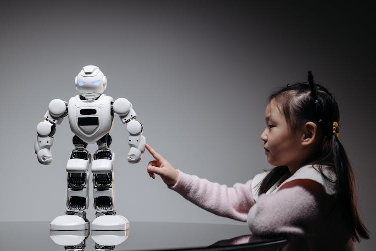 A Girl Touching The White Toy Robot