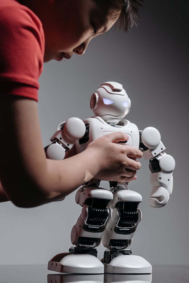 A Boy Holding A White Toy Robot