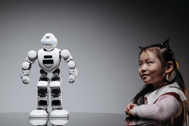 A Girl Looking At The White Toy Robot