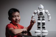 A Boy Holding a White Toy Robot