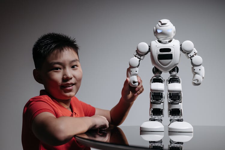 A Boy Holding A White Toy Robot