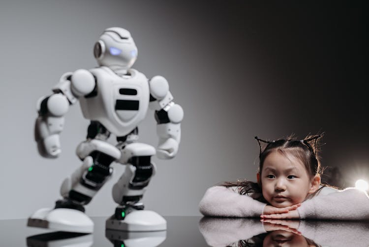 A Girl Looking At The White Toy Robot