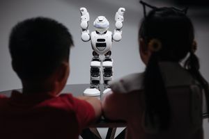 Двое детей наблюдают за роботом