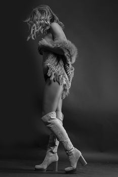 Elegant monochrome portrait of a woman in stylish boots with an artistic pose.