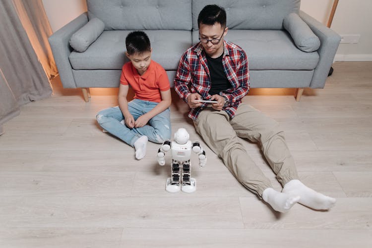 A Father Controlling A Robot With His Cellphone