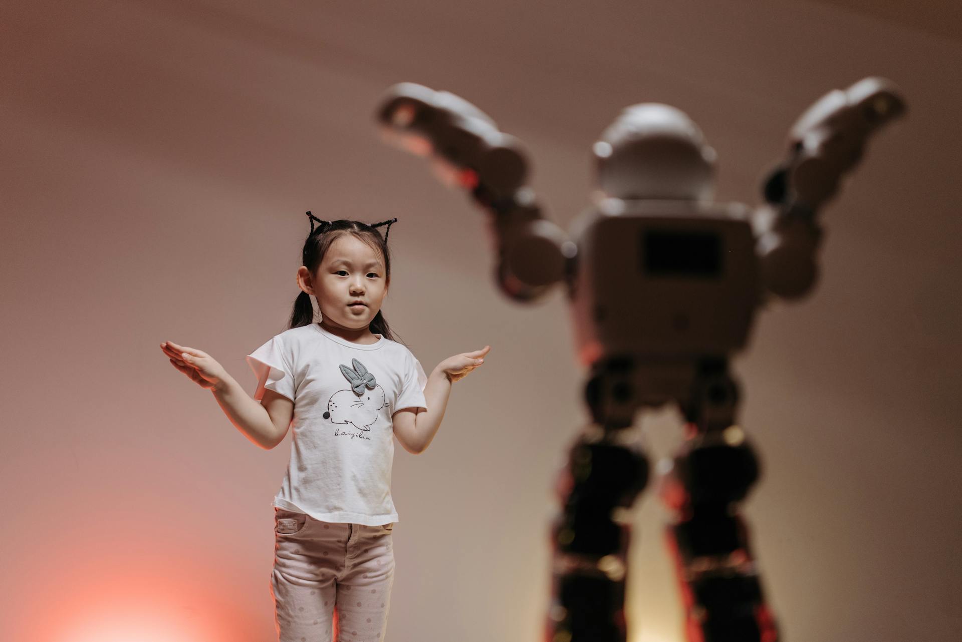 Child interacting with futuristic robot in a playful setting, showcasing modern technology.