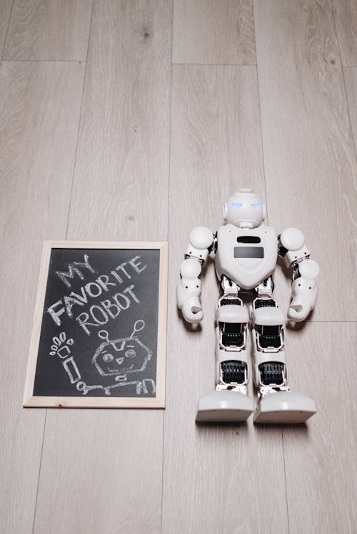 A Framed Board Beside a Robot on a Wooden Surface