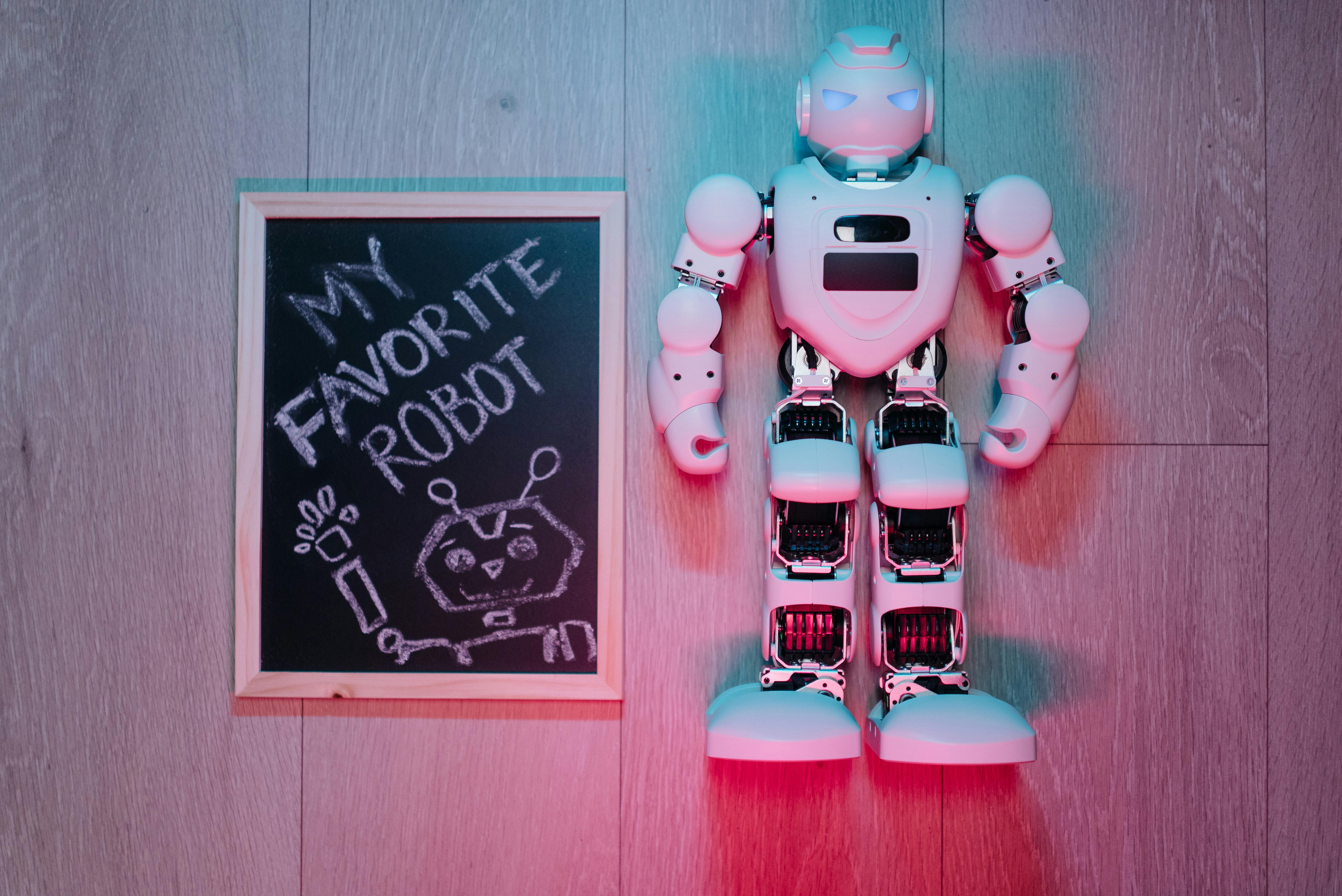 white robot on a wooden surface beside a board