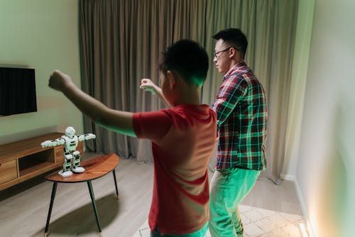 A Father and Son Imitating the Robot on the Wooden Table