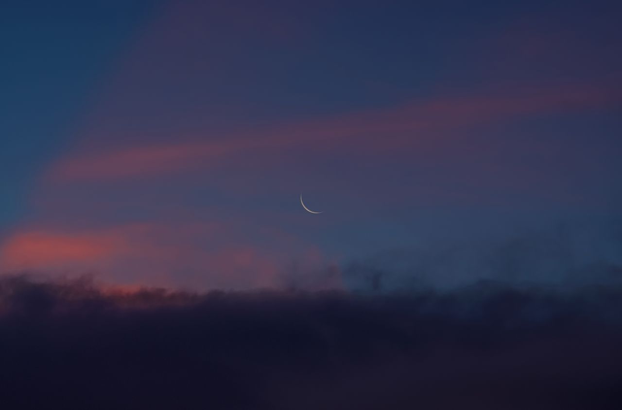 crescent moon in a serene twilight sky with colorful clouds in malita