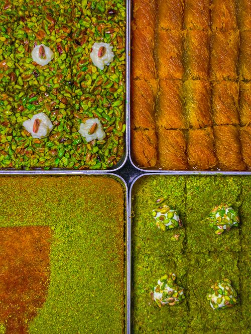 Free Close-up of assorted colorful Middle Eastern pastries including pistachio baklava and various sweets. Stock Photo