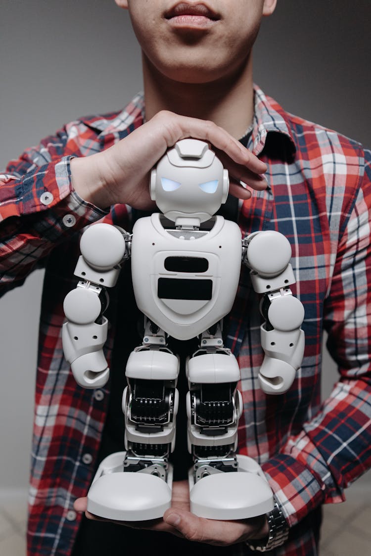 A Person Holding White And Black Robot Toy