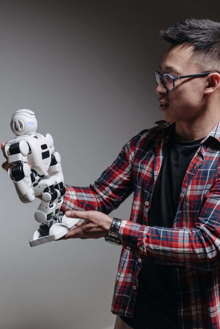 Person examining an AI powered humanoid robot in a technology workspace