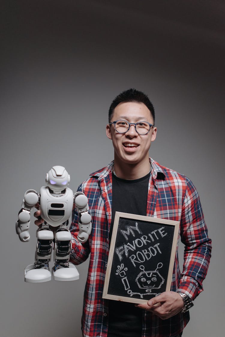 A Man Holding A Robot Toy