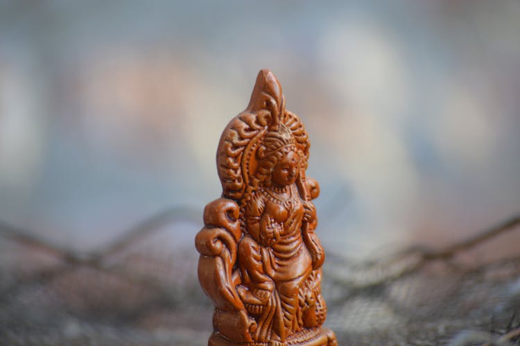 Close-Up Shot Of A Wooden Statuette Of Hindu God Lakshmi