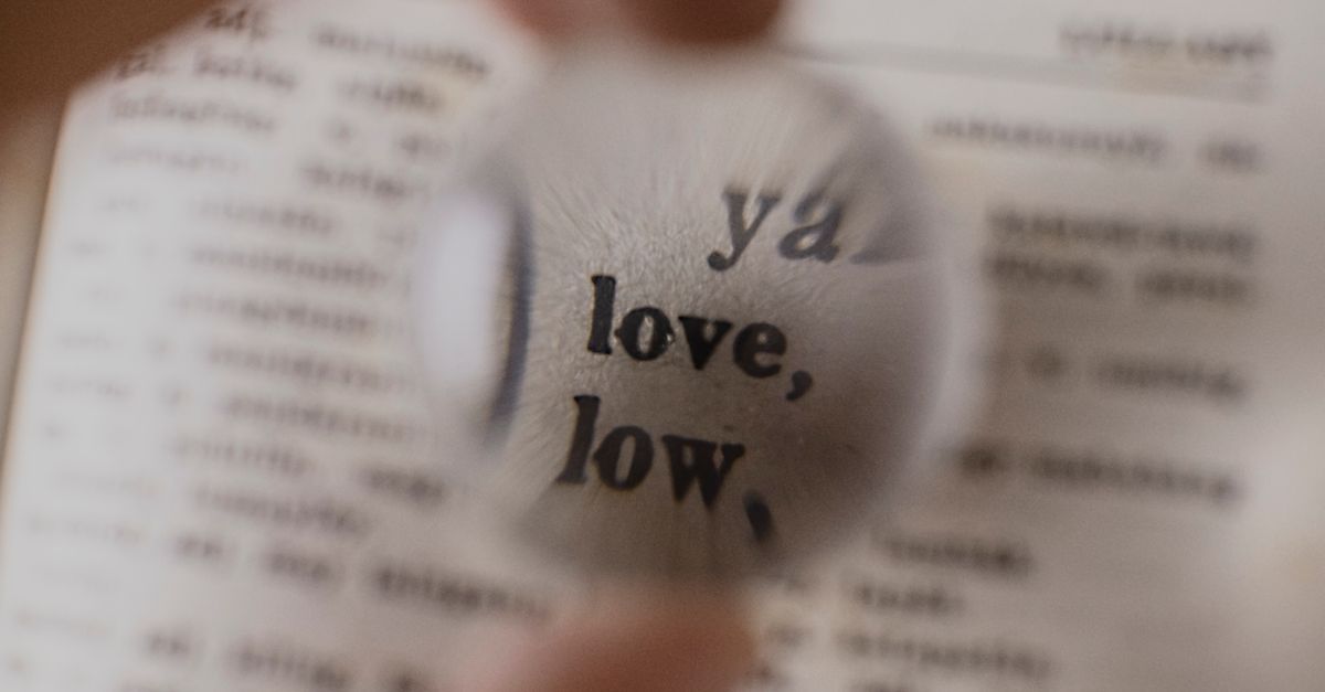 Gros plan sur une loupe mettant au point le mot 'amour' dans un dictionnaire.