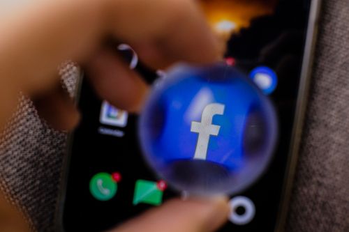 Free Close-up view of the Facebook app icon magnified on a smartphone screen. Stock Photo