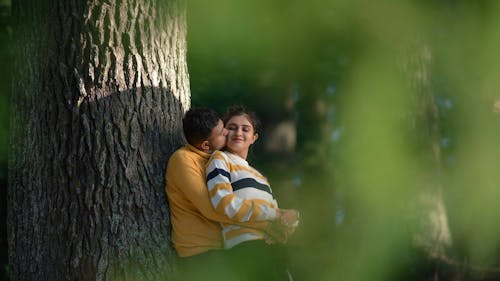 Free Man in Yellow Long Sleeve Shirt Leaning on Tree Stock Photo