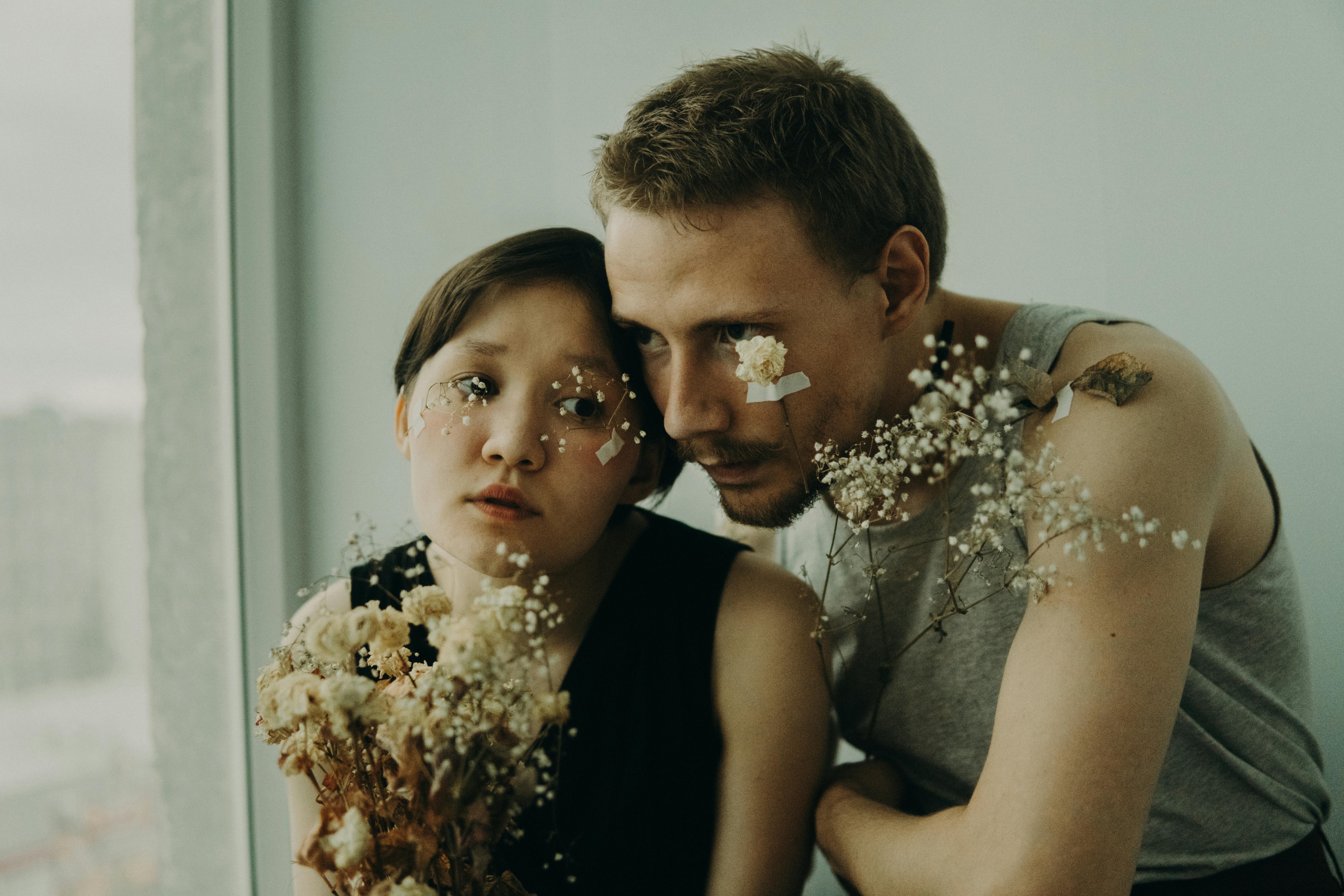 woman sitting with a man holding dried flowers