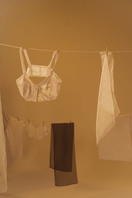 Free Hanging undergarments on a clothesline against a warm yellow background. Stock Photo