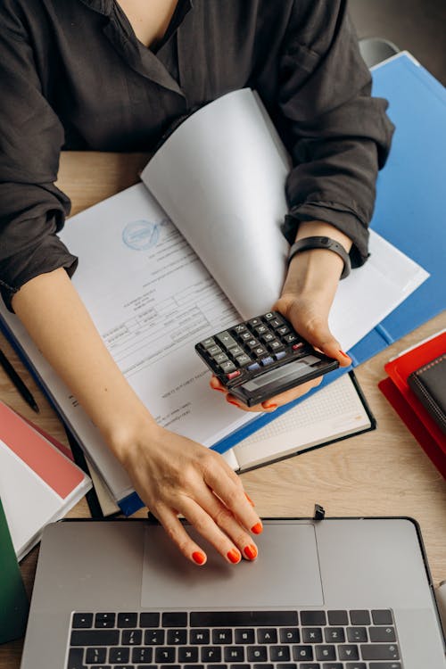 Free Person Holding Black Calculator While Using Laptop Stock Photo