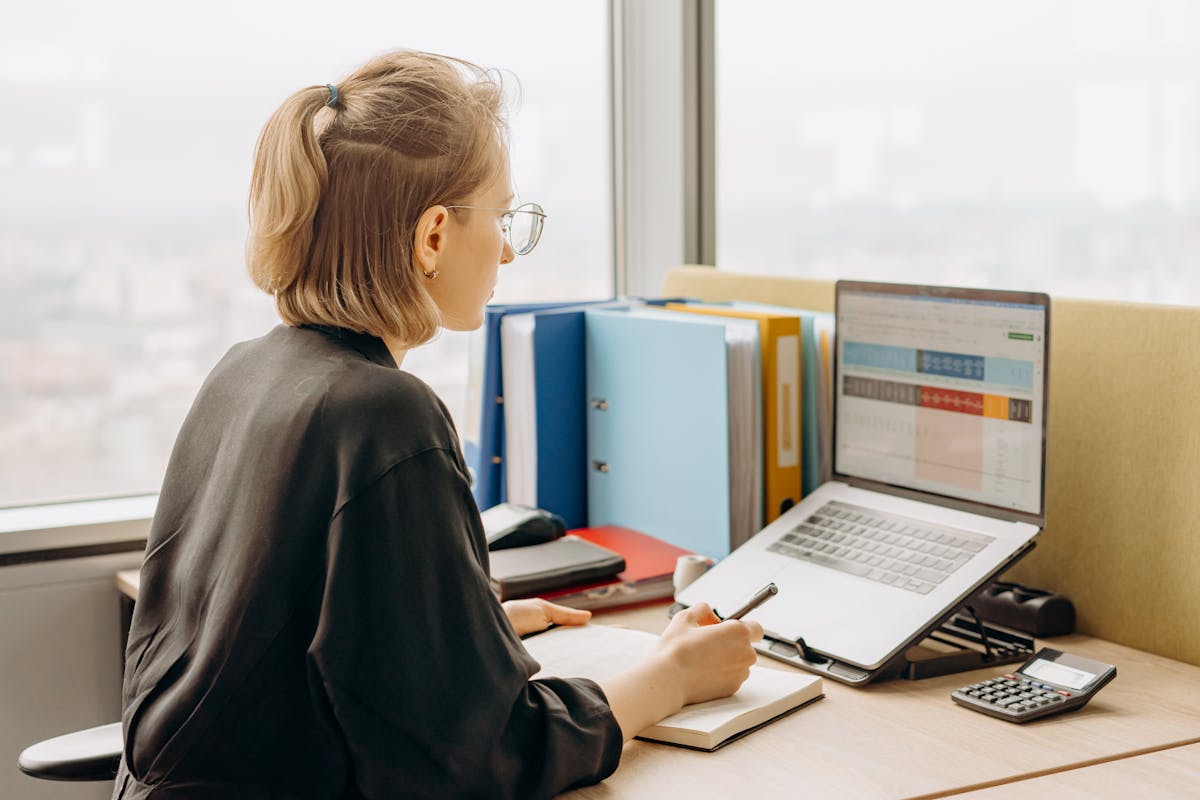 Professional woman working focused at desk with laptop