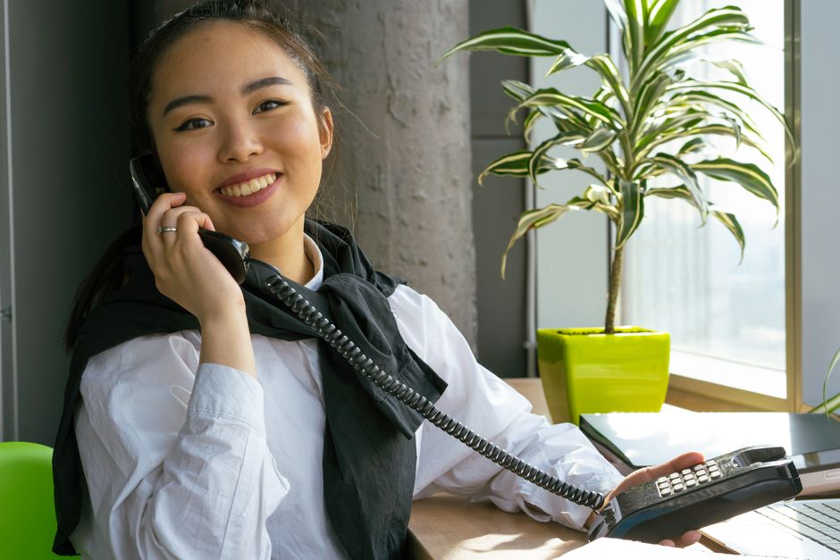 Smiling receptionist talking on the phone in bright clinic