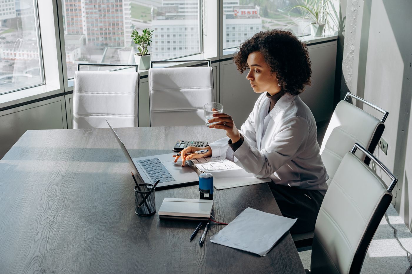African American woman working on a laptop in a bright office