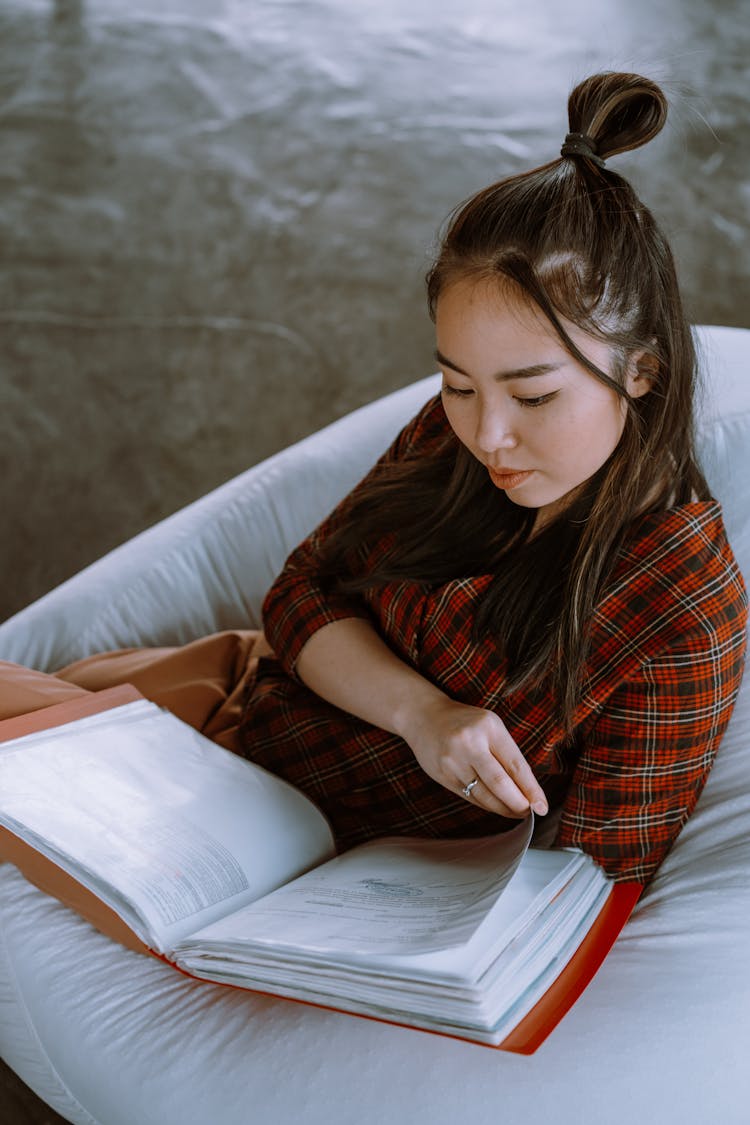 A Woman Examining A Folder Of Documents