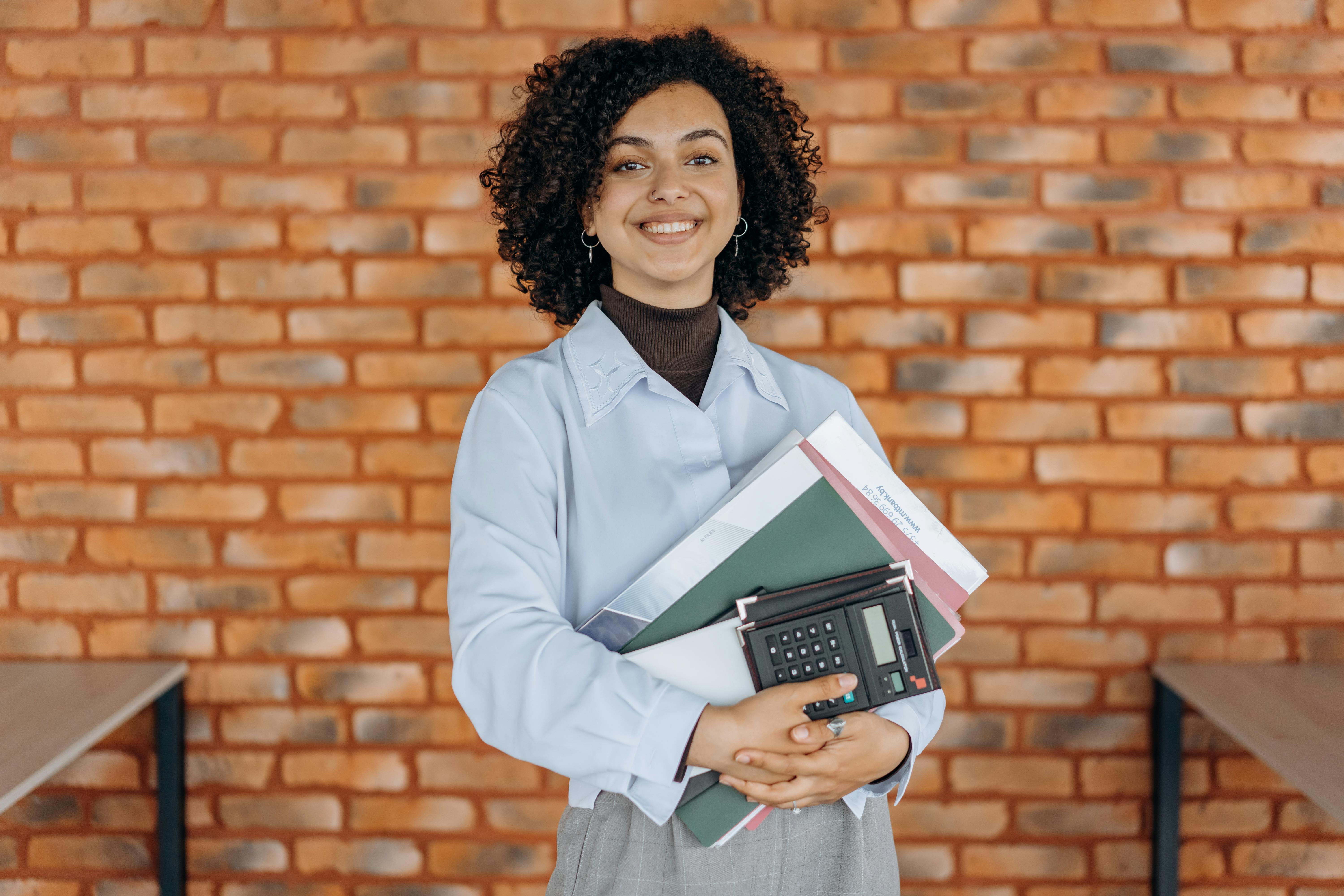 a working woman grasping folders and a calculator