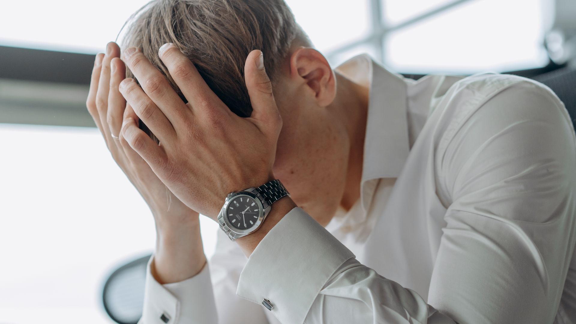 Modafinil for Adrenal Fatigue: Unlocking Energy and Focus A business professional showing stress and fatigue with head in hands — modafinil for adrenal fatigue