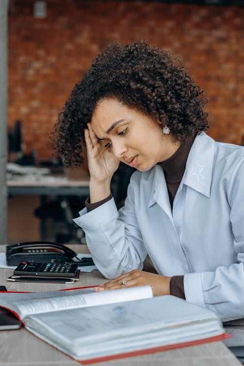 Free An Exhausted Woman Reading Files Stock Photo
