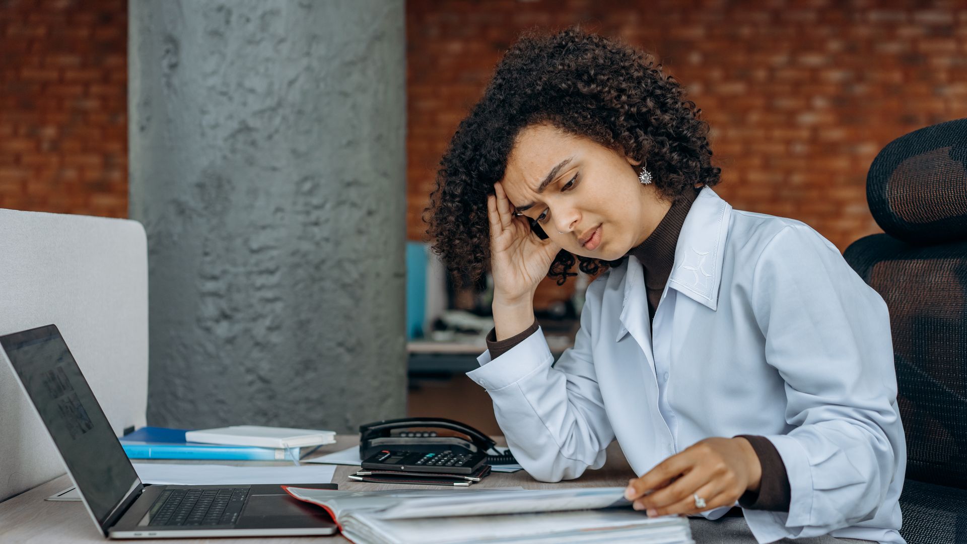 Modafinil for Adrenal Fatigue: Unlocking Energy and Focus Businesswoman experiencing fatigue while working on financial paperwork at her desk — modafinil for adrenal fatigue