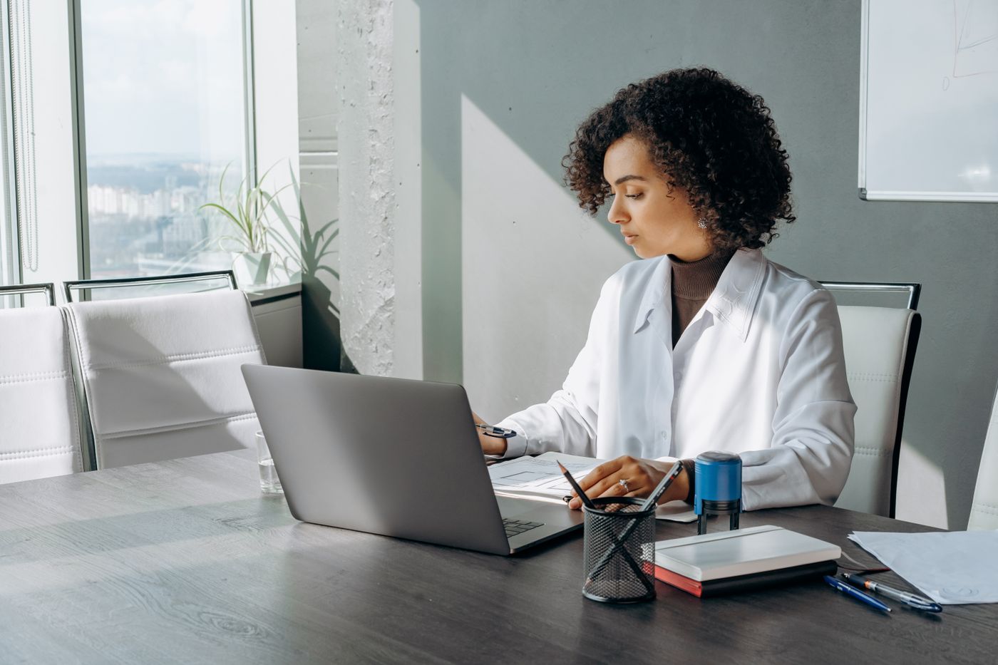 Professional woman working on a laptop in a bright office