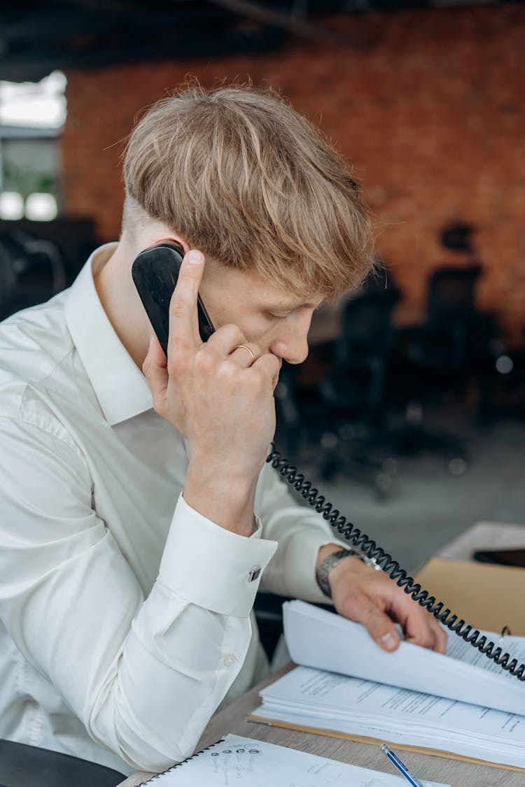 Man Sitting At Table Talking On The Phone