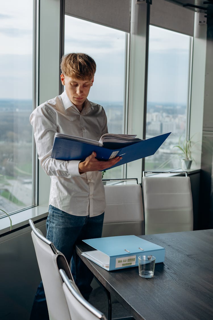 
A Man Reading Documents In A Binder