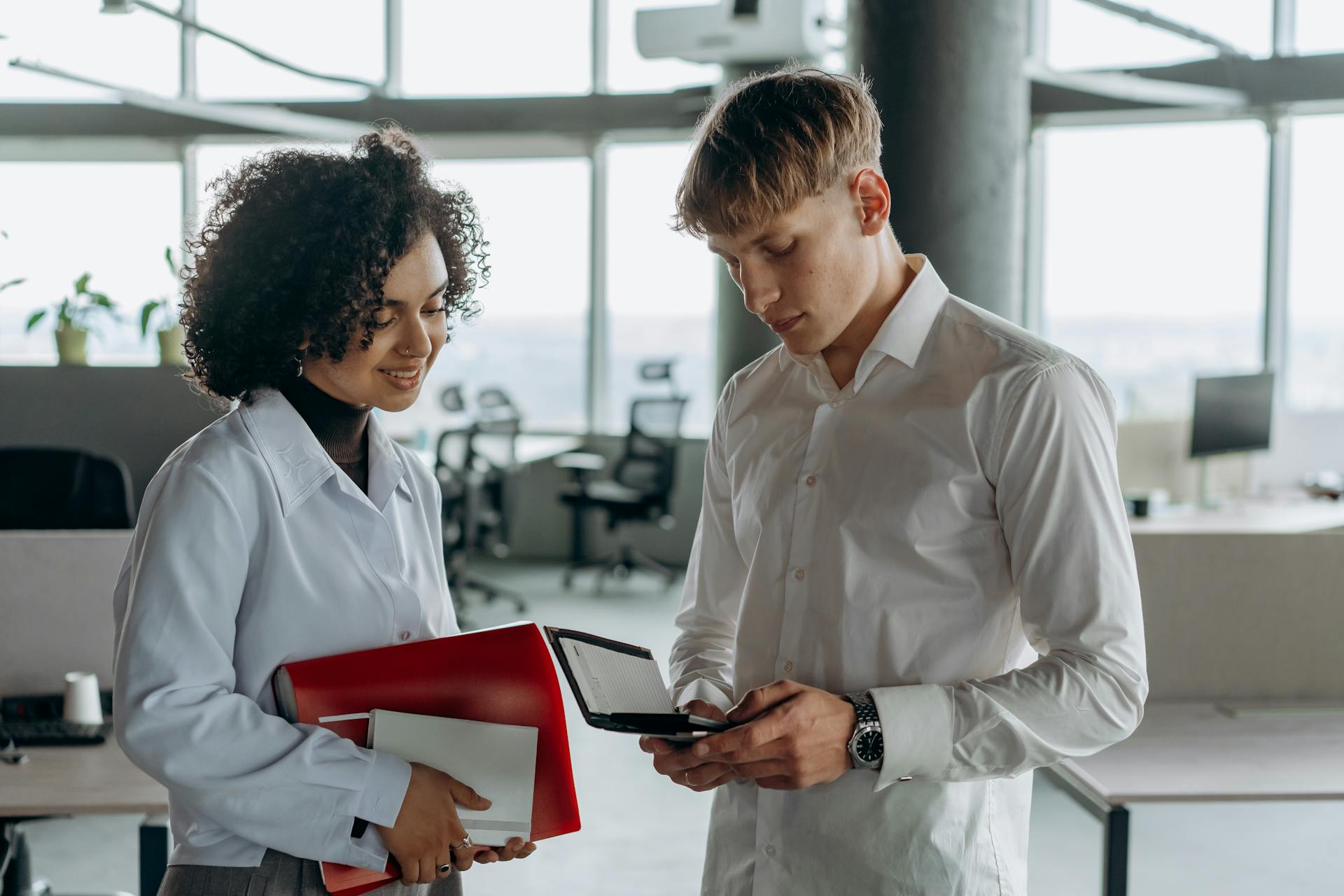 Colleagues Standing in White Long Sleeve Shirts Calculating Financial Report Using a Calculator