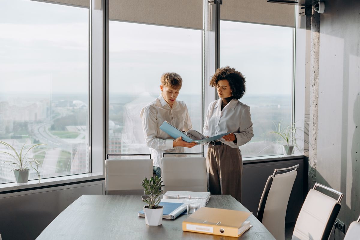 Professional man and woman discussing business documents in an office