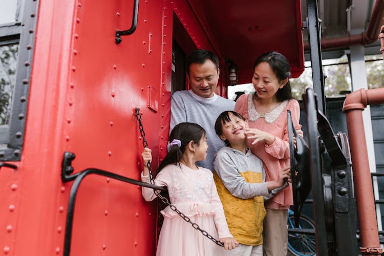 A Happy Family Standing On The Train 