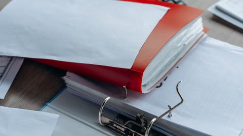 Tidy office desk with binders, papers, and stationery, ideal for business or education themes.