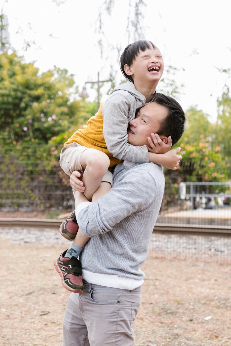 A Man Carrying A Child Laughing