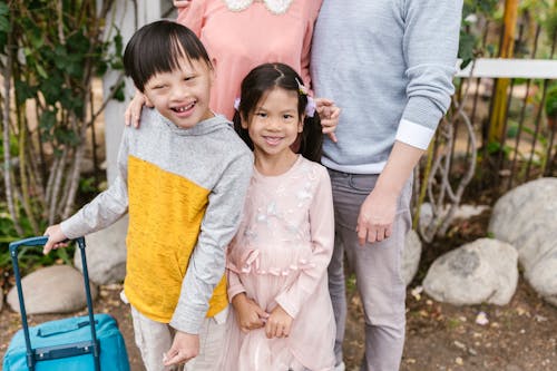 Siblings Standing Next to Each Other Beside their Parents