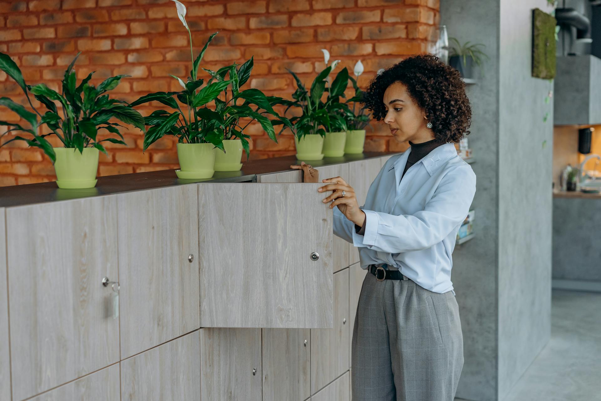 Curly Haired Woman Opening a Wooden Locker