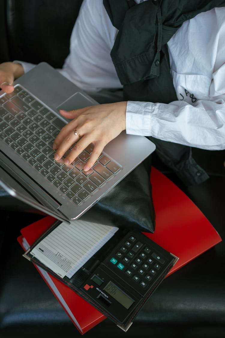 A Person Typing On The Laptop