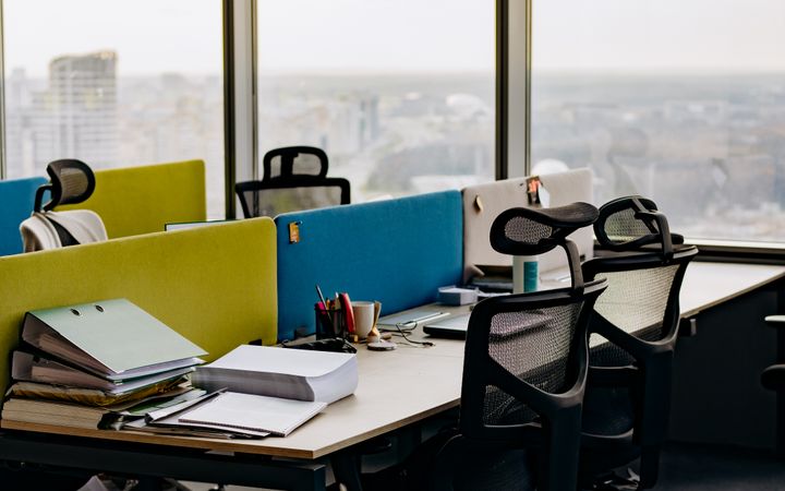 Open office space with colorful dividers and a city view, typifying modern urban work environments.