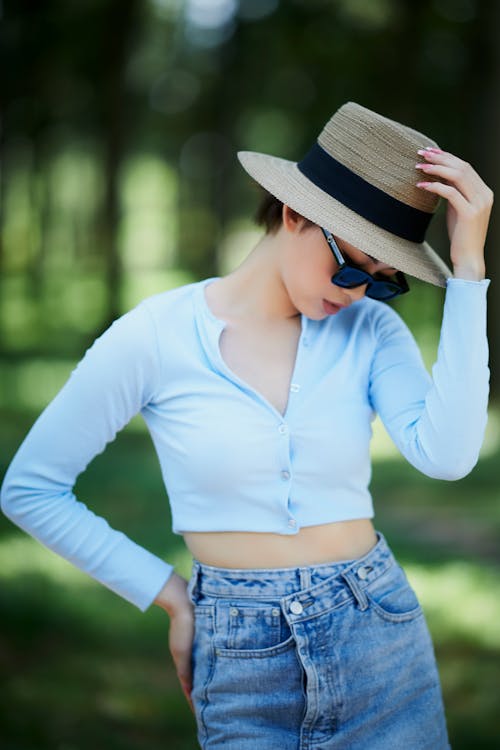 A Woman Wearing Sunglasses Looking Down with Her Hand on Her Waist